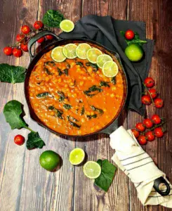 A bowl of creamy vegan coconut chickpea curry garnished with fresh cilantro, served with rice.