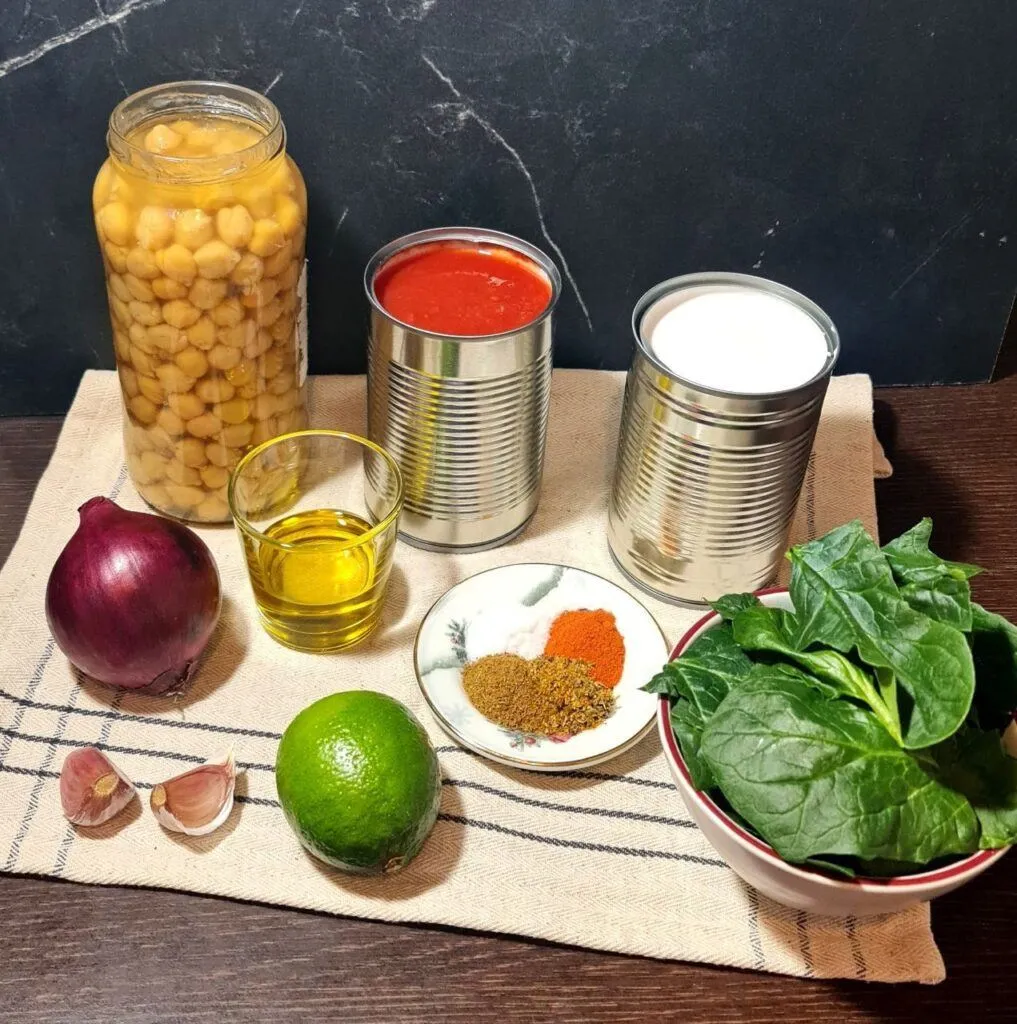 A bowl of vegan coconut chickpea curry garnished with fresh cilantro, served with rice and lime wedges.