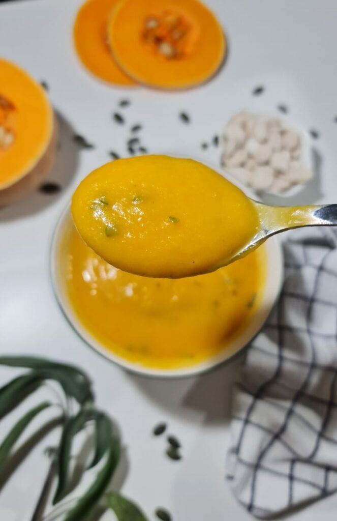 Tablespoon with butternut squash soup with bowl