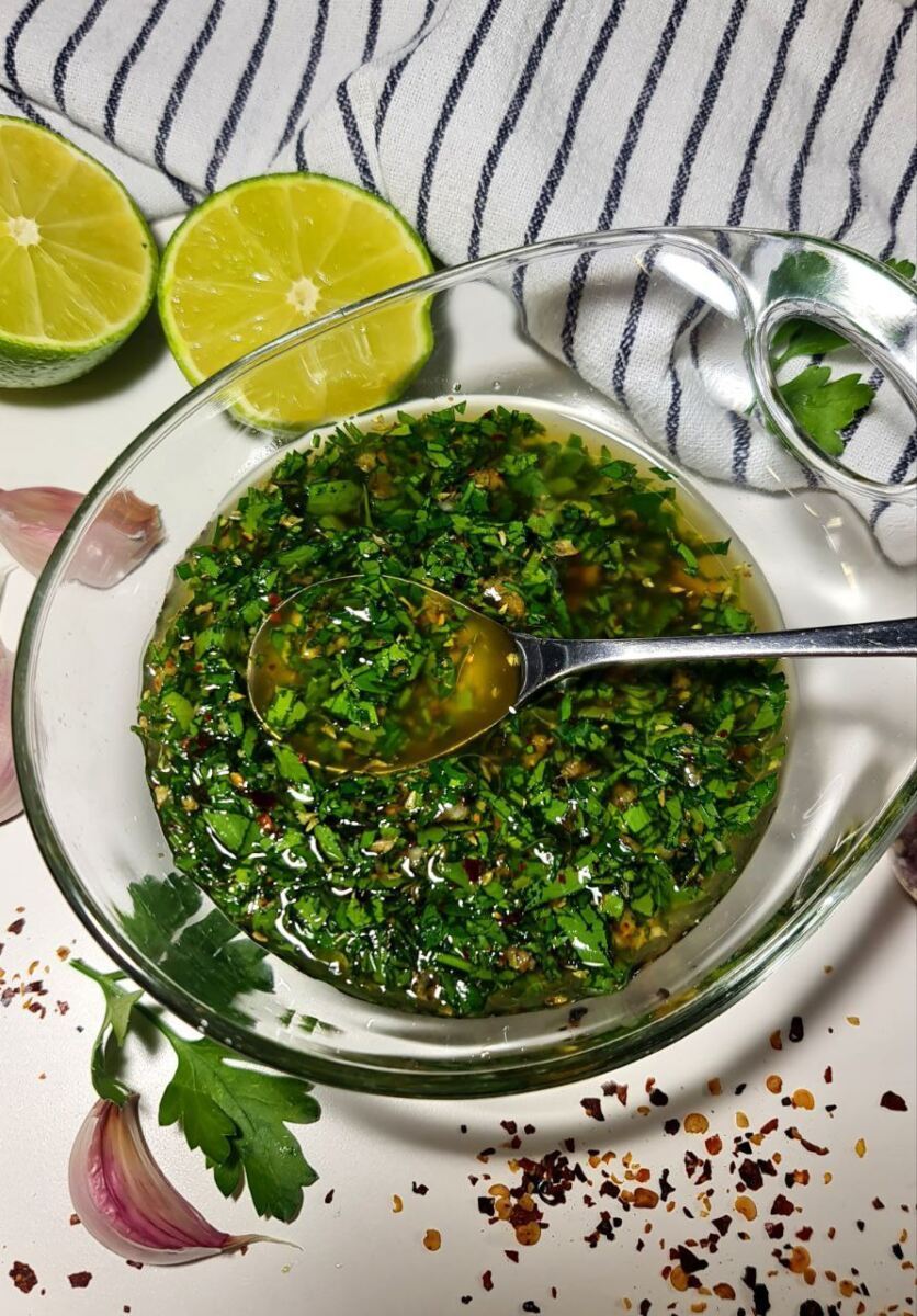 A bowl of vibrant chimichurri sauce made with fresh herbs, garlic, and vinegar.