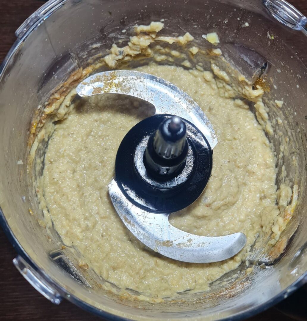 "Blended baba ganoush in a food processor, showing the smooth, creamy texture of the dip after combining all ingredients.