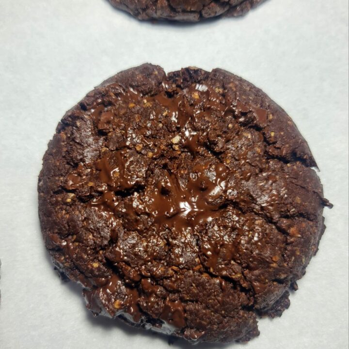 Best vegan chocolate cookies arranged on a wooden table with a cooling rack in the background