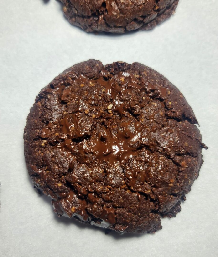 Best vegan chocolate cookies arranged on a wooden table with a cooling rack in the background