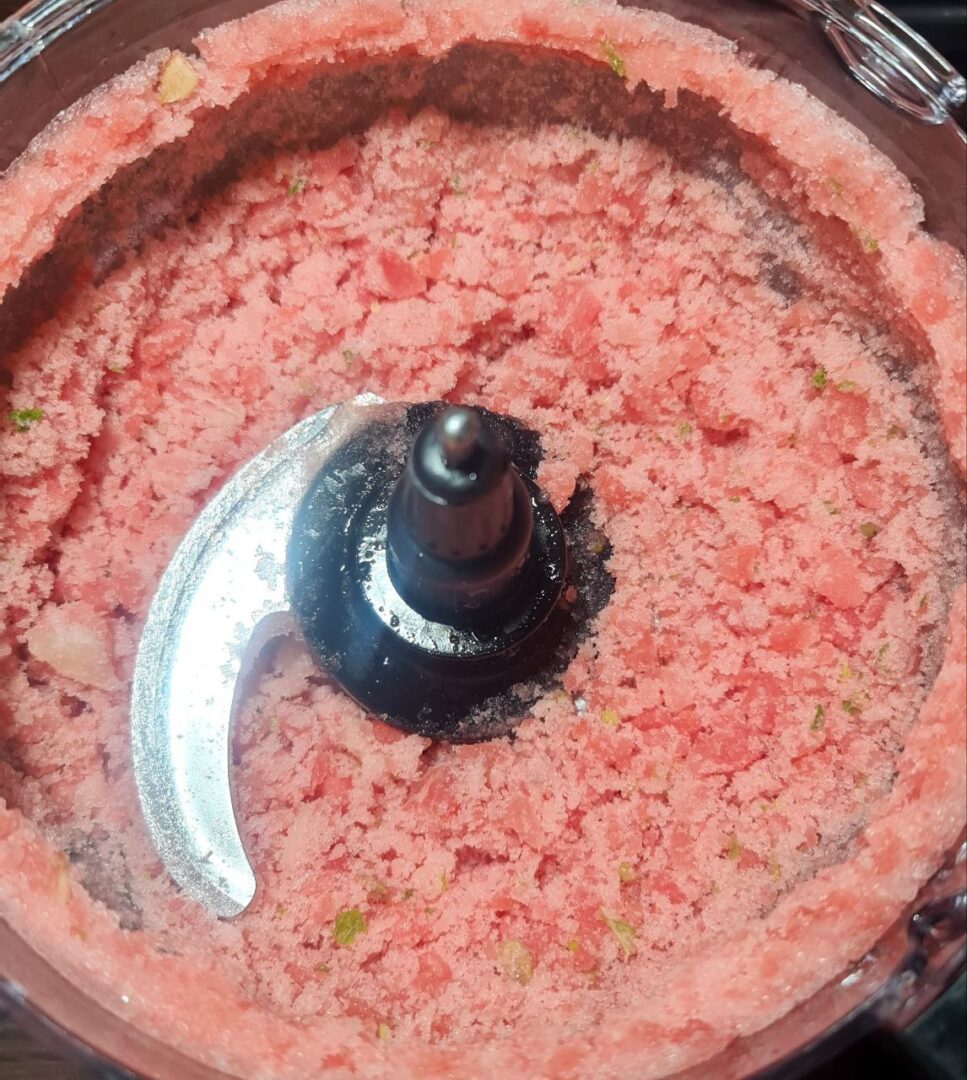  Close-up view of blended watermelon slushie mixture in a food processor.