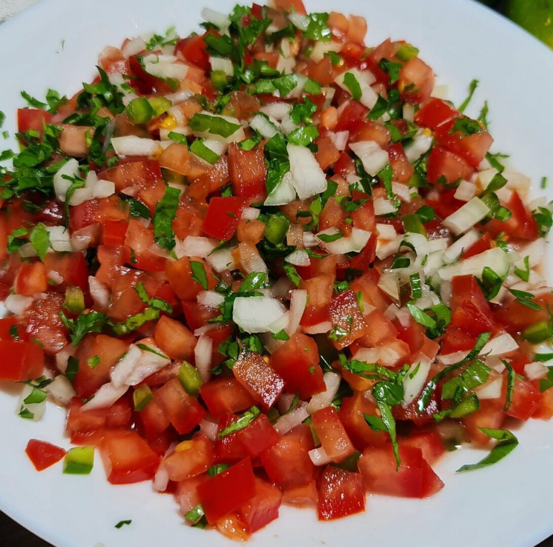  Close-up of freshly made pico de gallo with diced tomatoes, onions, cilantro, and jalapeños.