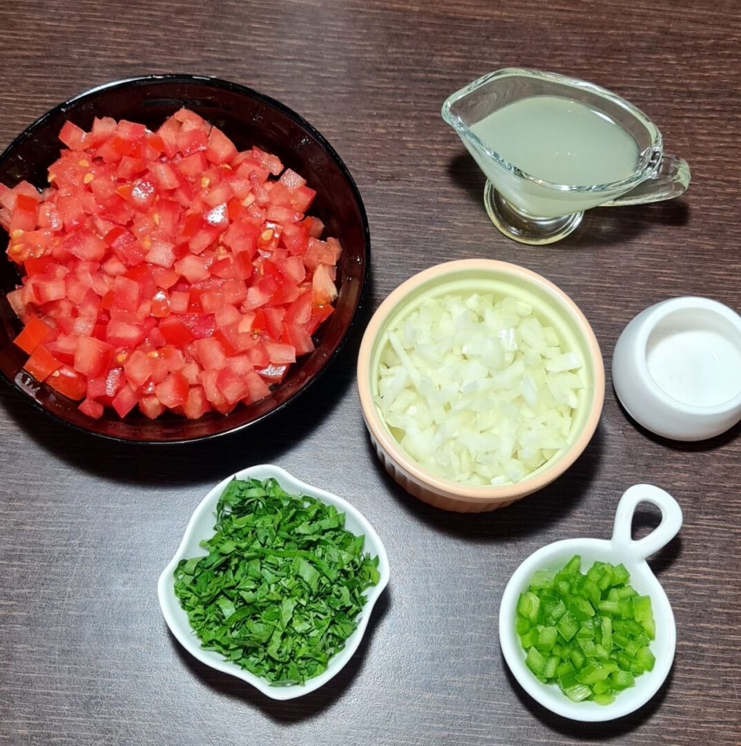  Ingredients for pico de gallo including diced tomatoes, onions, cilantro, jalapeños, lime juice, and salt.