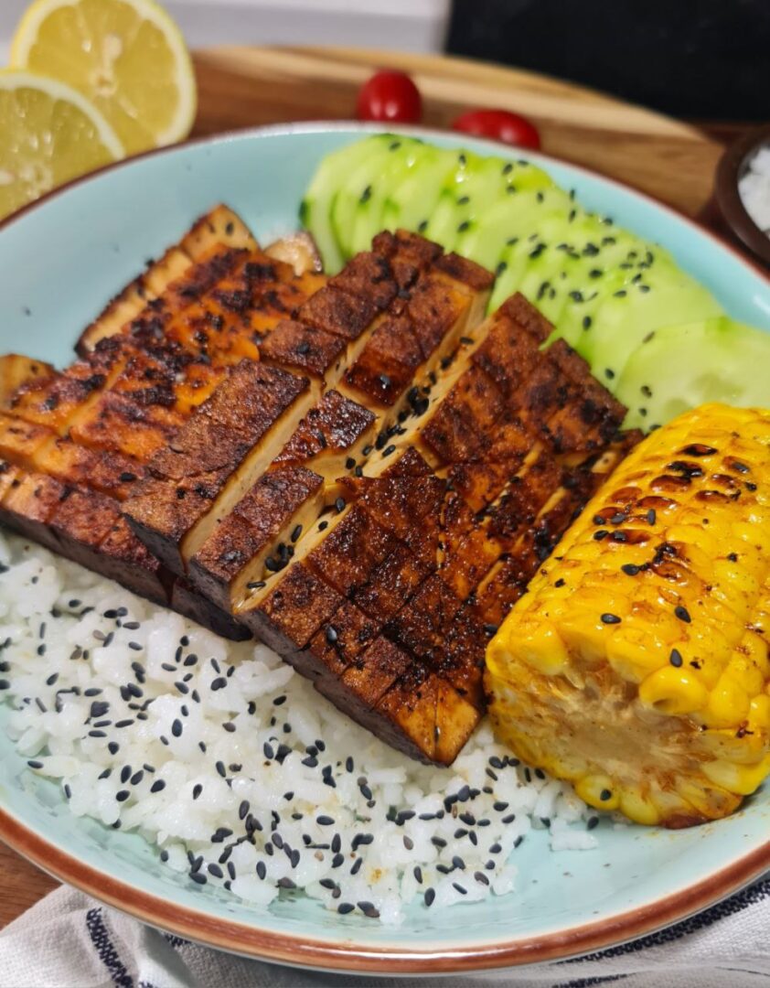 a plate of food with rice and tofu