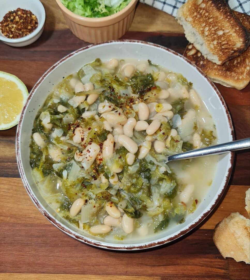 a bowl of soup with a spoon and bread