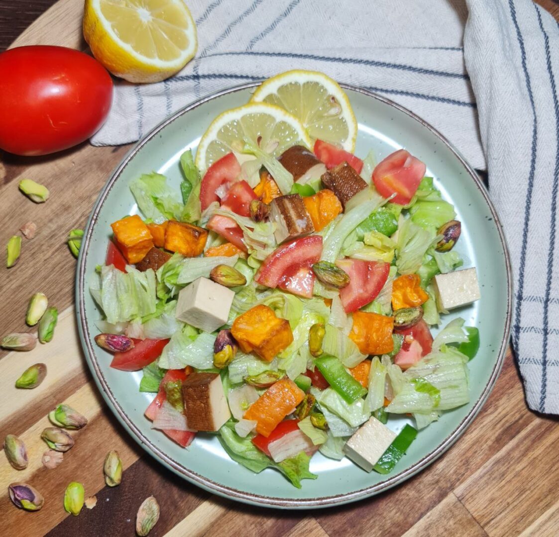 a plate of salad with tomatoes and tofu