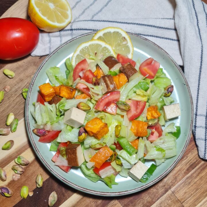 a plate of salad with tomatoes and tofu