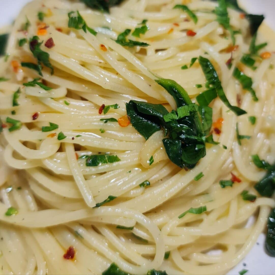 a plate of spaghetti with herbs on top