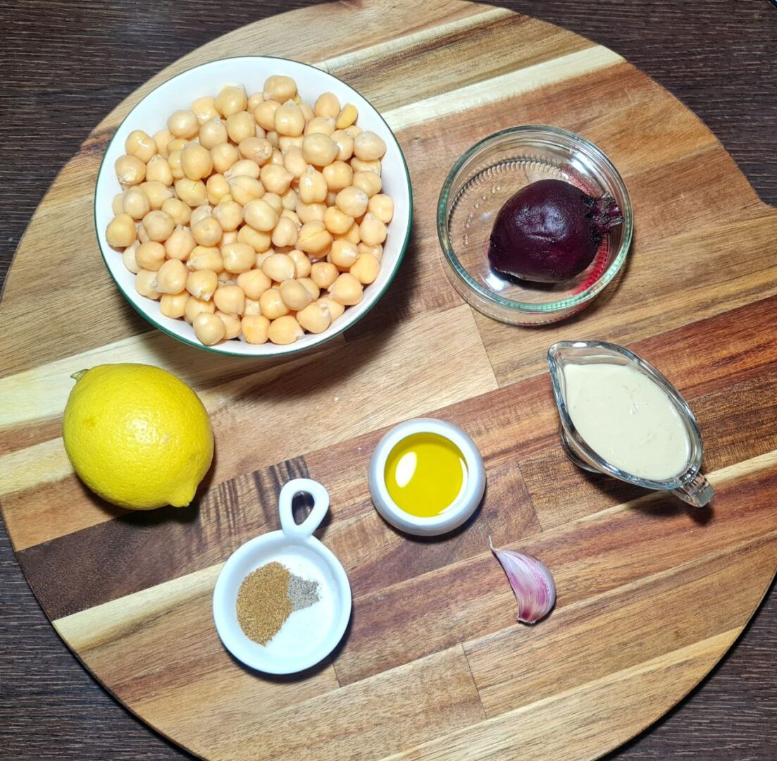 Ingredients for beetroot hummus including chickpeas, beetroot, lemon, tahini, olive oil, garlic, and seasoning. All the ingredients for a delicious beetroot hummus recipe, featuring chickpeas, beetroot, lemon, tahini, and more.