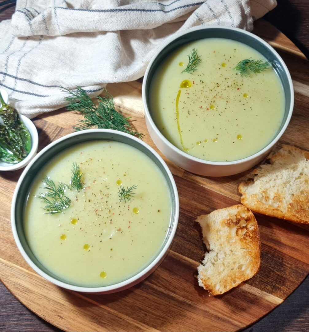 Bowl of creamy vegan cauliflower fennel soup garnished with dill and served with toasted bread. A comforting bowl of creamy vegan cauliflower fennel soup, garnished with fresh dill and served with toasted bread.