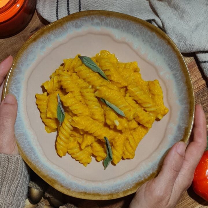 A bowl of creamy vegan pumpkin pasta garnished with sage leaves. Creamy vegan pumpkin pasta garnished with fresh sage