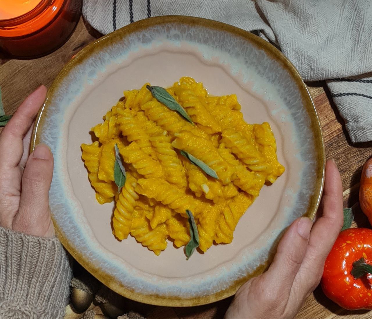 A bowl of creamy vegan pumpkin pasta garnished with sage leaves. Creamy vegan pumpkin pasta garnished with fresh sage