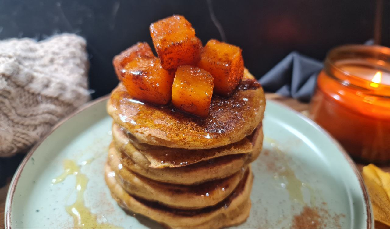 a stack of pancakes with orange cubes on top