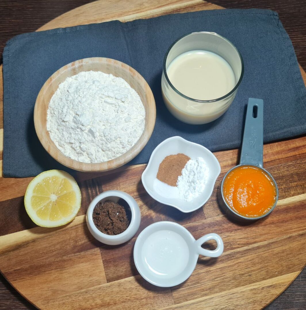 a wooden board with ingredients for vegan pumpkin pancakes on it