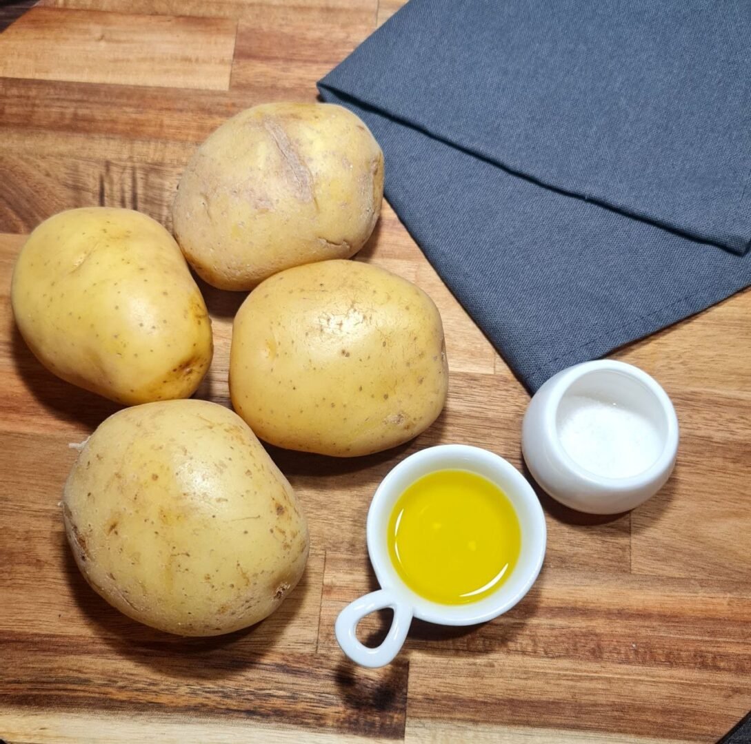 a group of potatoes and a small cup of oil