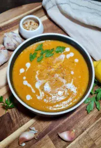 a bowl of butternut squash abs sweet potato soup with parsley and garlic