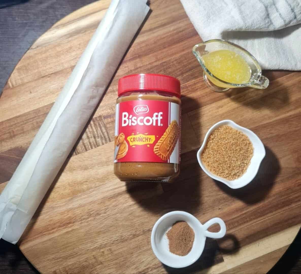 A variety of ingredients for Biscoff swirls, including Biscoff spread, puff pastry, sugar, butter, and spices.