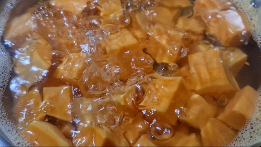 Cubes of sweet potatoes boiling in water for vegan mashed sweet potatoes recipe. Sweet potatoes boiling to perfect tenderness for vegan mashed potatoes.