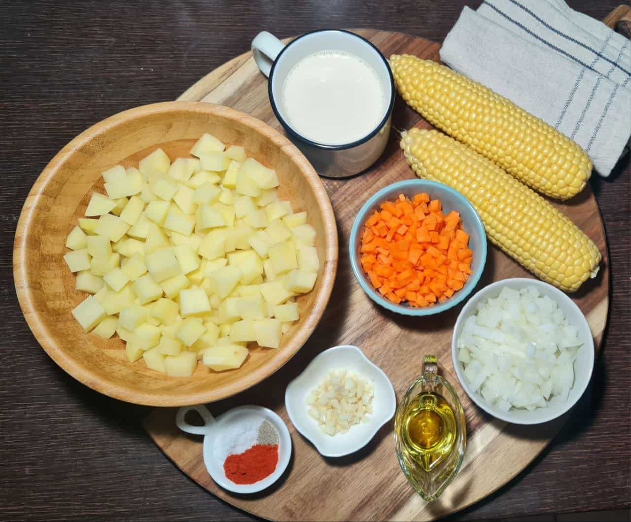  Fresh ingredients for corn chowder including corn, potatoes, carrots, celery, onions, garlic, and fresh herbs. Fresh and colorful ingredients for making a delicious corn chowder.