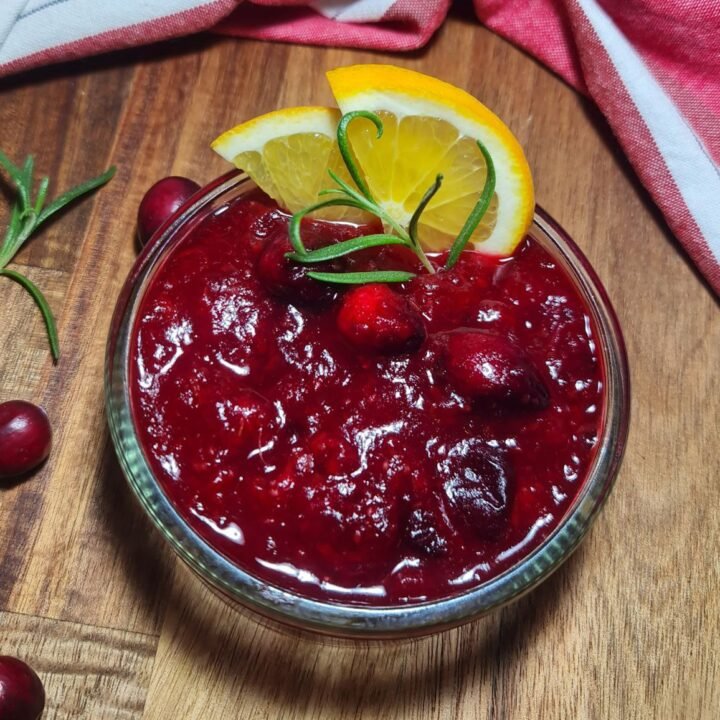 Bowl of homemade cranberry sauce with orange zest garnish, perfect for holiday meals.