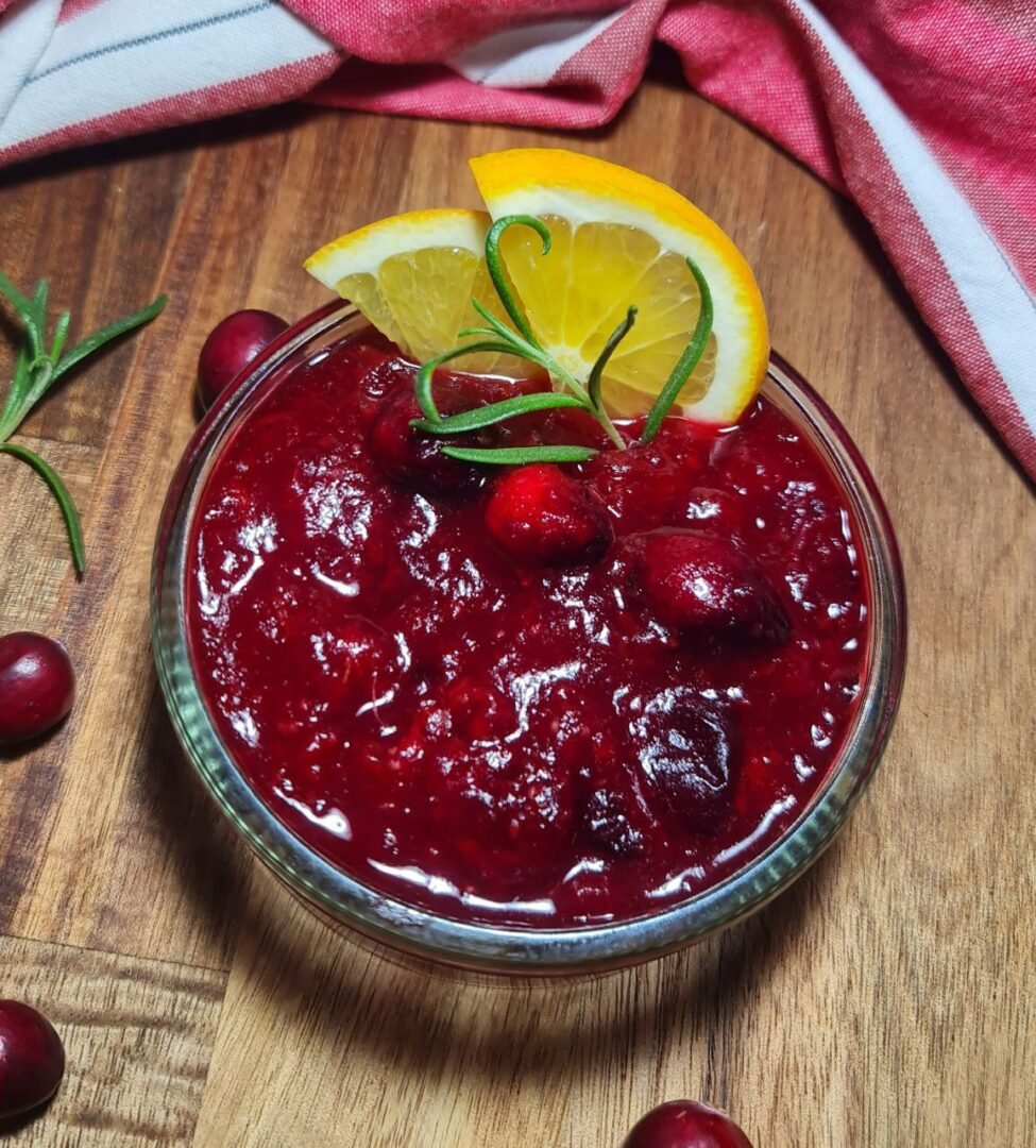 Bowl of homemade cranberry sauce with orange zest garnish, perfect for holiday meals.