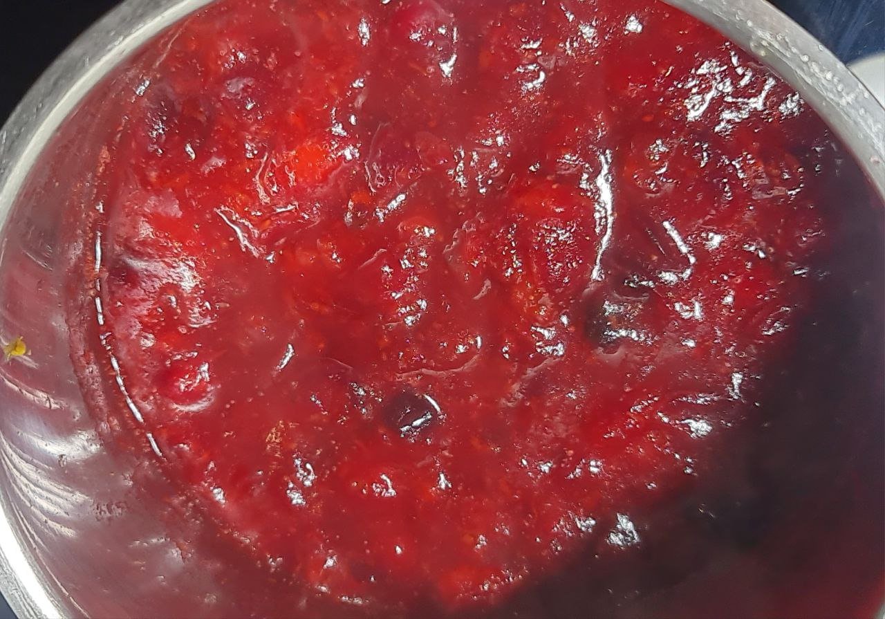 A pot of homemade cranberry sauce simmering on the stove.  Homemade cranberry sauce simmering on the stove, perfect for holiday meals.