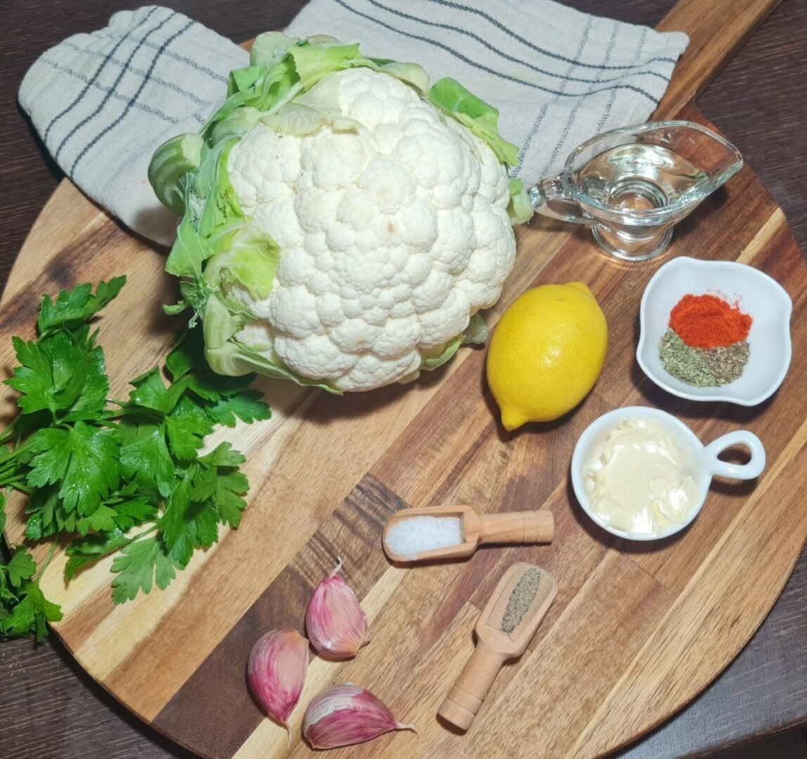 a cauliflower and spices on a cutting board