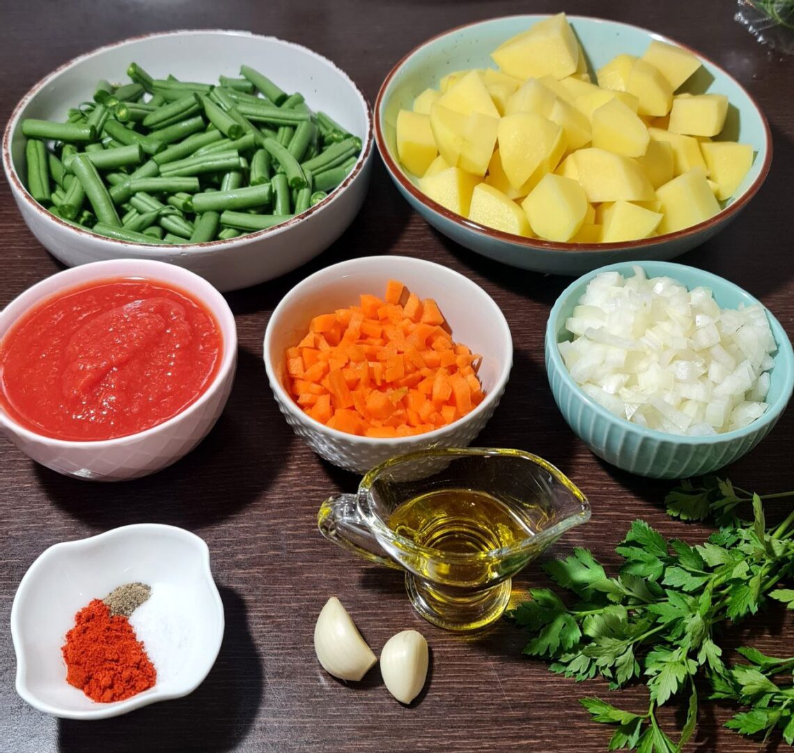  Ingredients for potato and green beans soup including green beans, potatoes, tomato sauce, carrots, onions, olive oil, garlic, spices, and parsley.