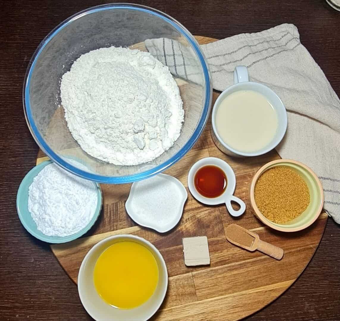 Ingredients for vegan cinnamon rolls including flour, powdered sugar, and melted butter.