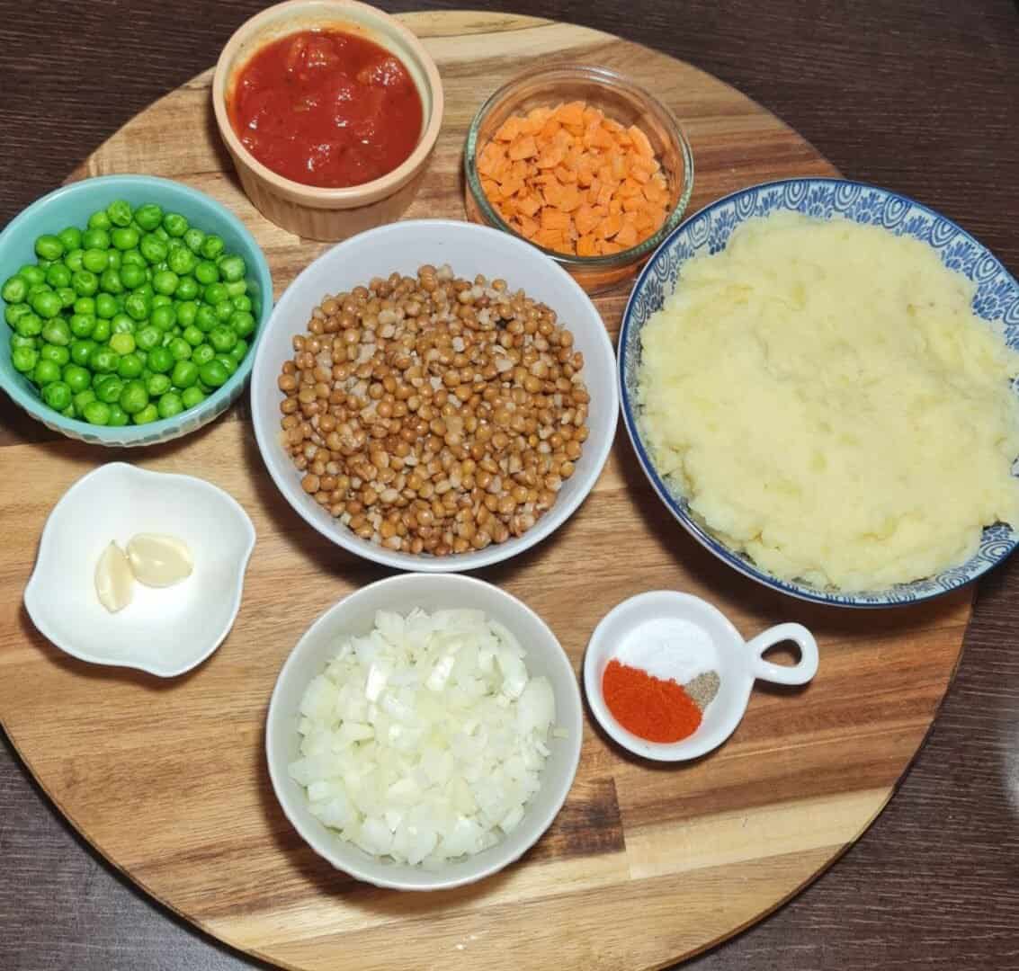 -  Ingredients for vegan shepherd's pie including peas, lentils, mashed potatoes, carrots, onions, garlic, tomato sauce, and spices.
- Caption: Ingredients for a delicious vegan shepherd's pie: peas, lentils, mashed potatoes, carrots, onions, garlic, tomato sauce, and spices.