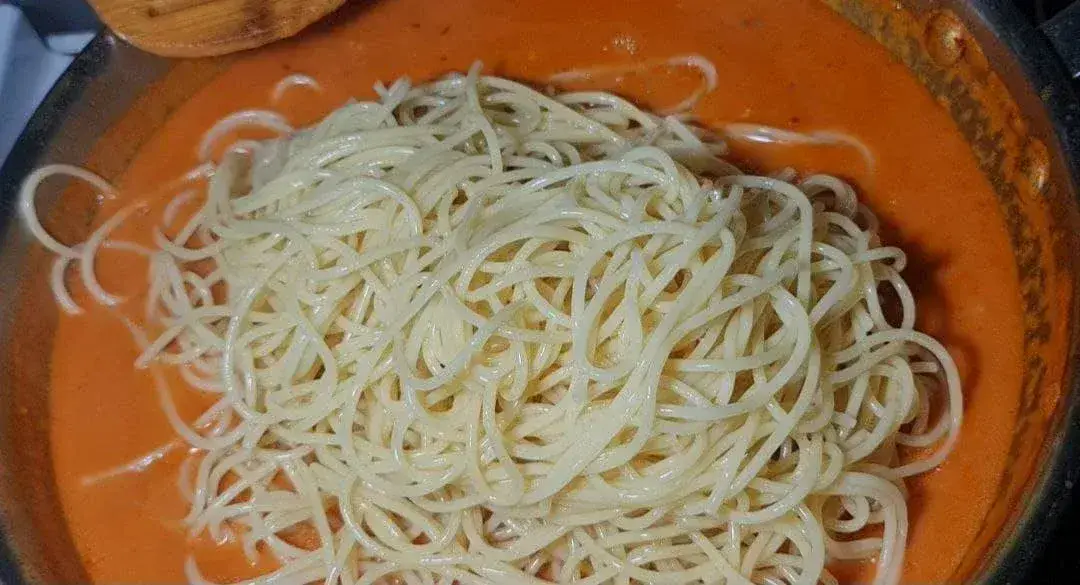  A bowl of cooked spaghetti noodles in a creamy coconut milk pasta sauce.