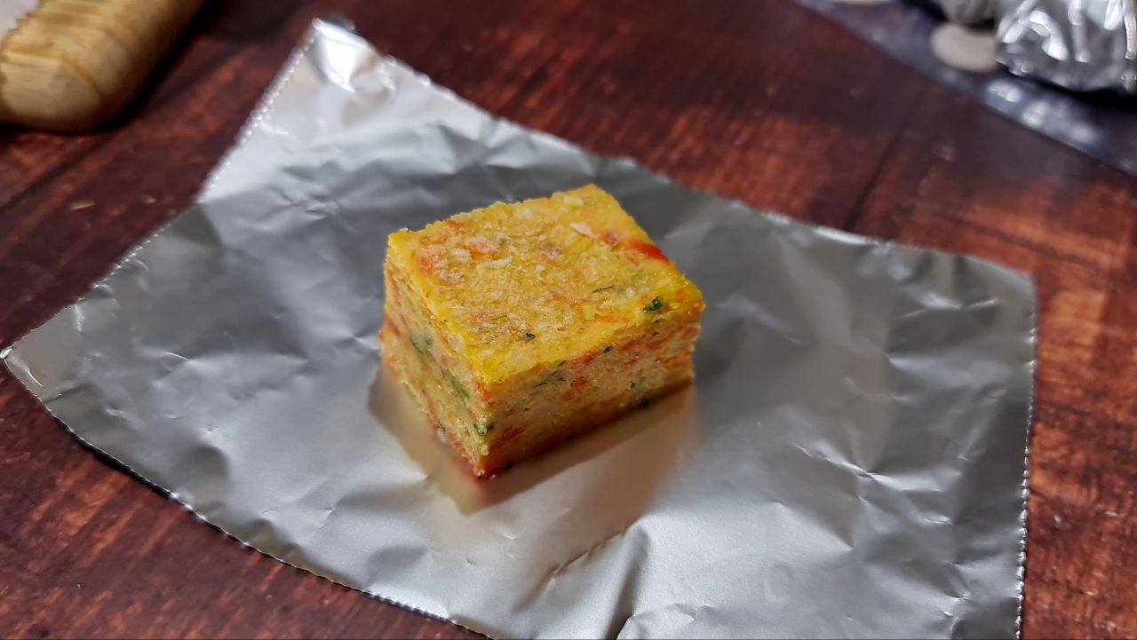 A homemade vegetable broth cube placed on a sheet of aluminum foil.