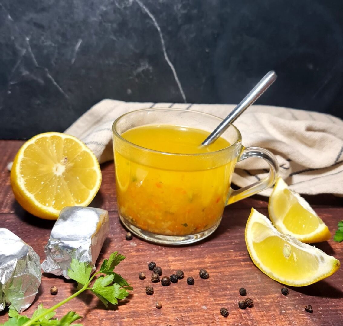 Homemade vegetable broth cubes with lemon, parsley, and black pepper on a wooden table.