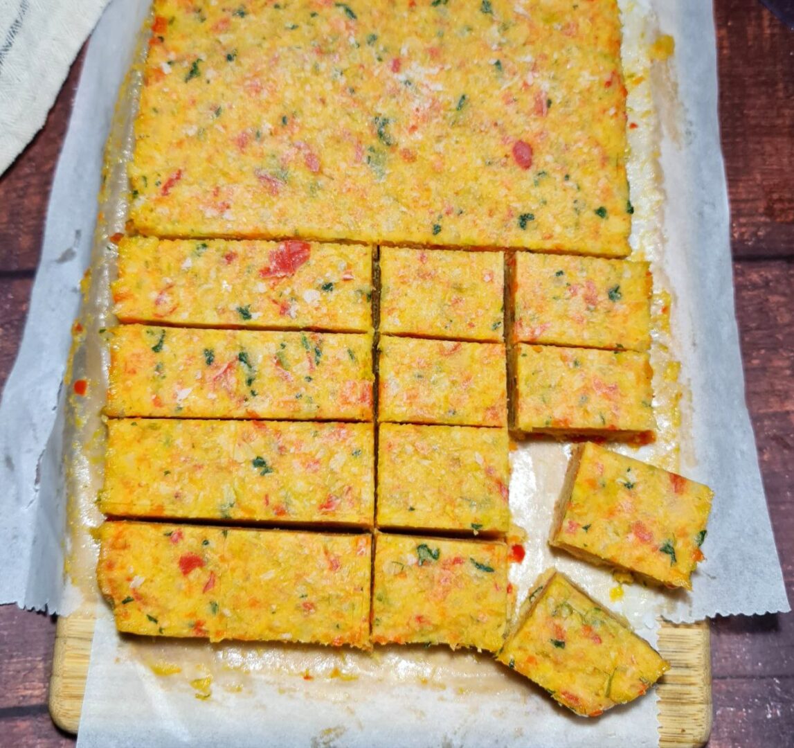 Homemade vegetable broth cubes cut into squares on parchment paper.