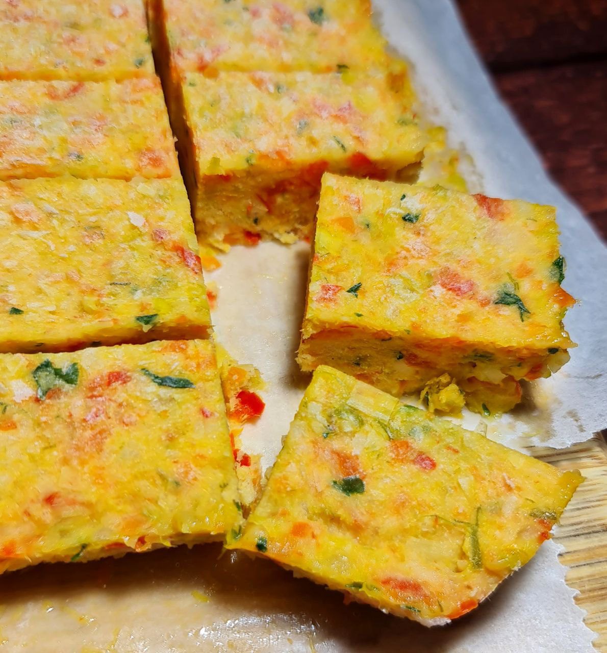 Homemade vegetable broth cubes cut into squares on parchment paper.