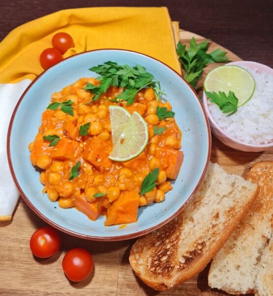 Bowl of one pan sweet potato curry with parsley and chili flakes