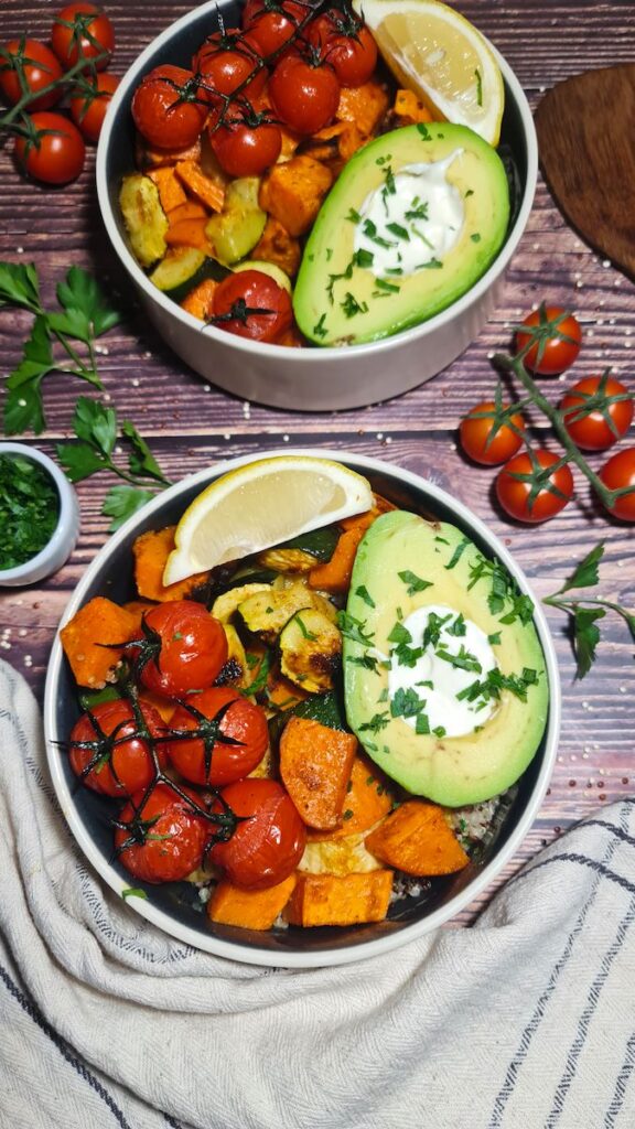 Detailed overhead look at a fresh roasted vegetable quinoa bowl featuring sweet potatoes, zucchini, and an avocado.