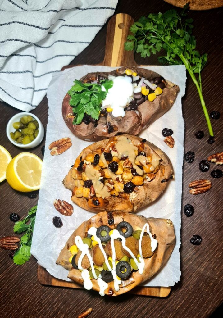 Text: Top-down vertical shot of three hearty vegan stuffed sweet potatoes with different plant-based proteins.