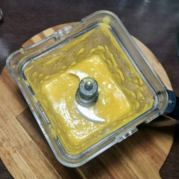 Pumpkin zucchini soup being blended in a blender until smooth.