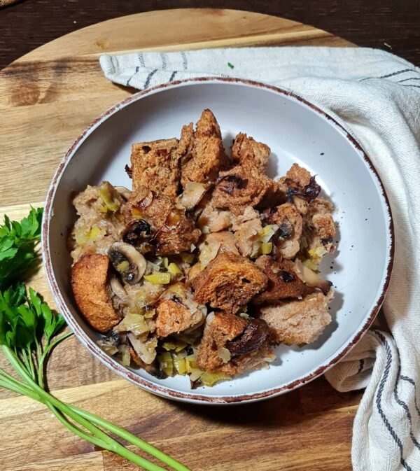 Baked vegan stuffing in a casserole dish with crispy golden edges.